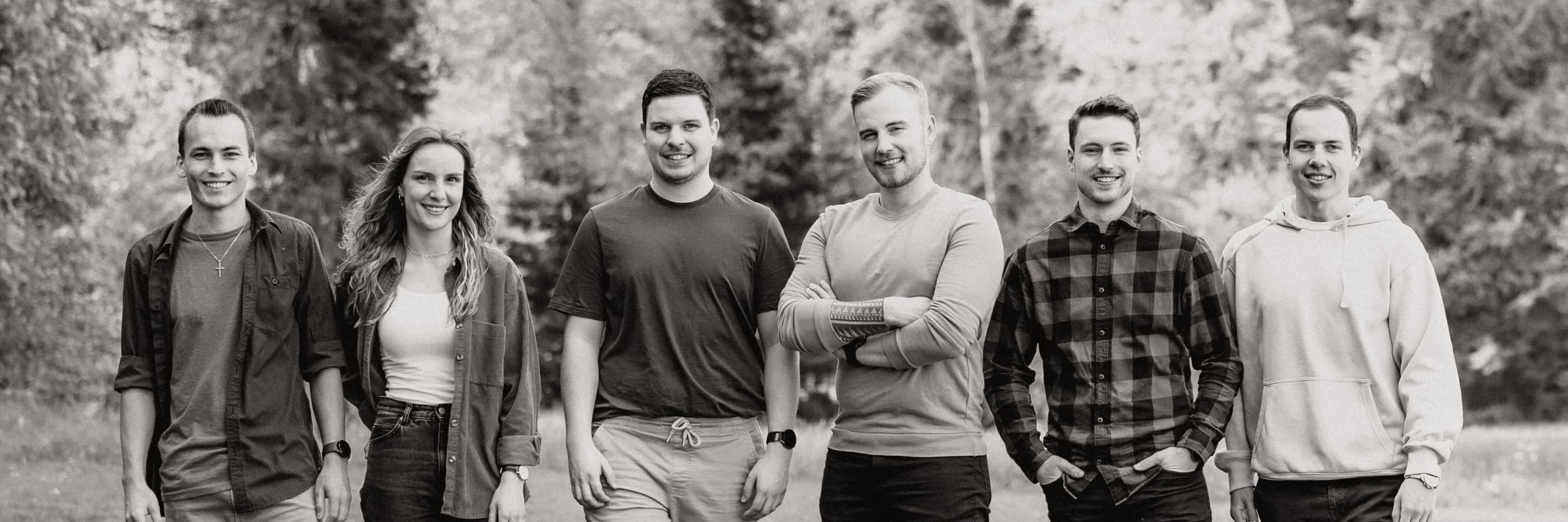The band standing in a field, black and white